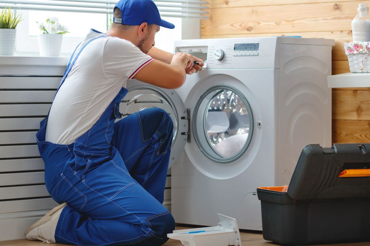 Мастер ремонтирует стиральную машину
